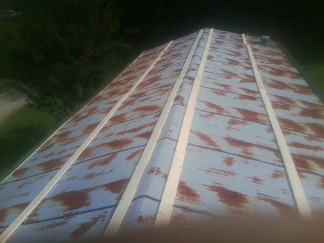 Rusted metal roof panels with new wood purlins before replacement — Storm Damage Roof Repair in Davidsonville by Roofing Brothers