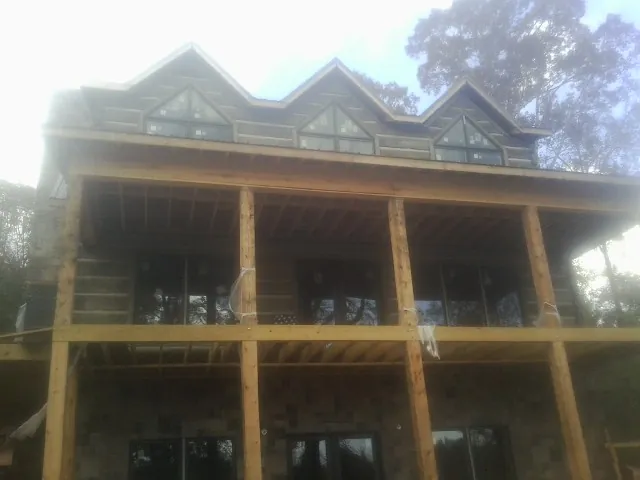 Dormers and porch framing on a large log home under construction — Roof Coating work by our crew in Davidsonville