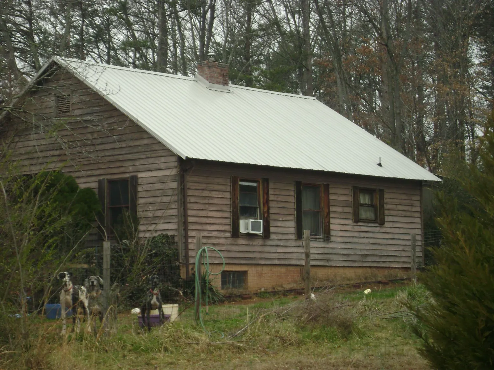 White metal roof on an old wood sided farmhouse, from a Asphalt Shingle Roof Repair job in Davidsonville